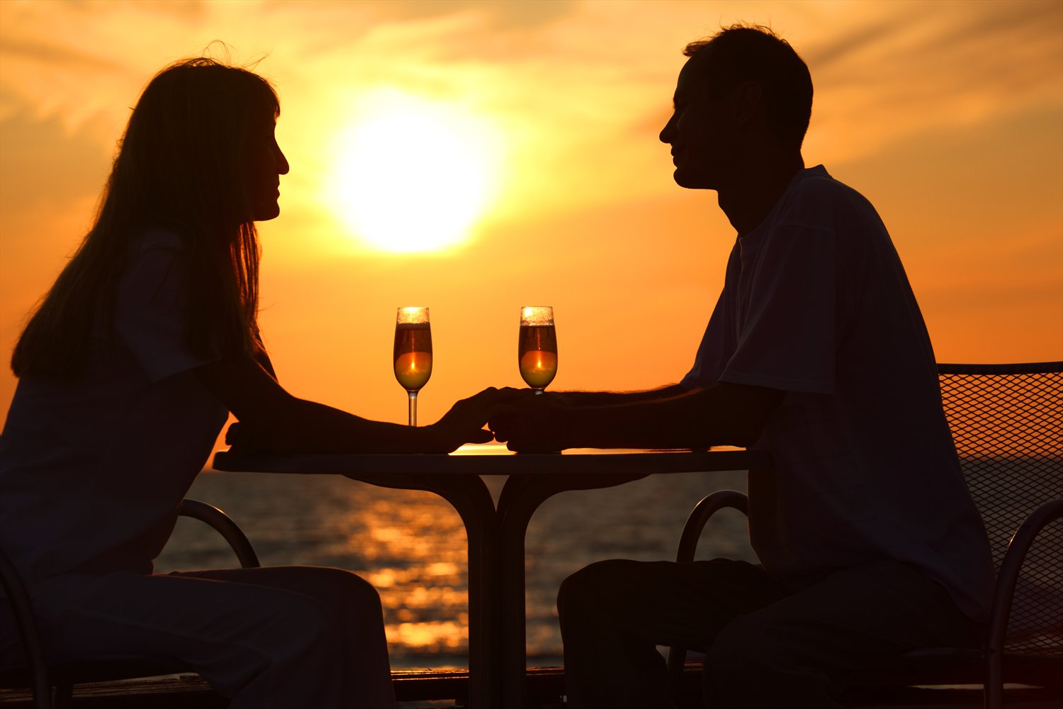 Coppia che brinda con prosecco al tramonto, rappresentando il comfort e il lusso del servizio NCC durante le festività.