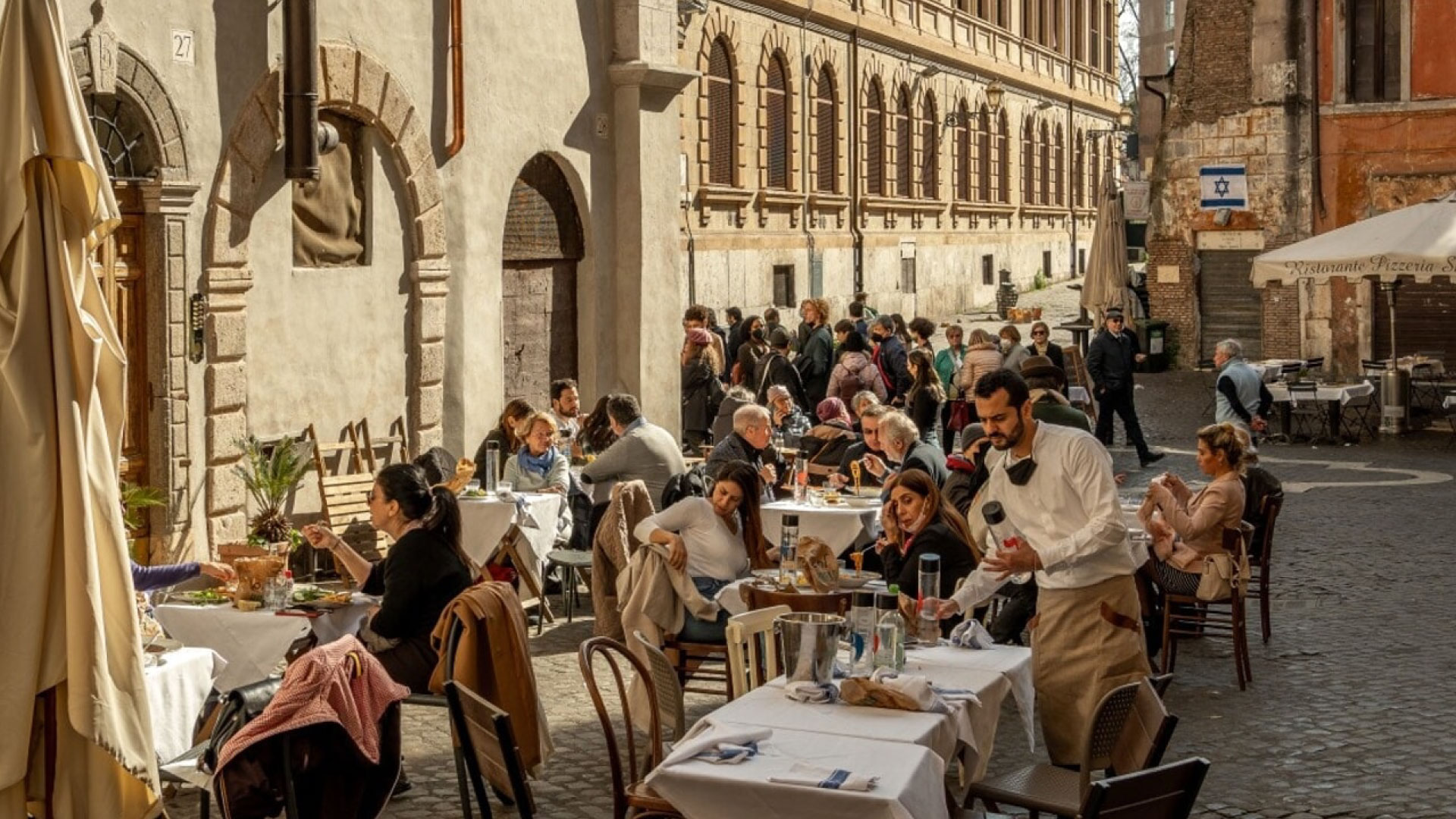 Persone che mangiano all’aperto in un ristorante romano, godendo dei piatti tipici della cucina romana. I Segreti della Cucina Romana: Piatti Tipici da Non Perdere con Roman Limousine Service.